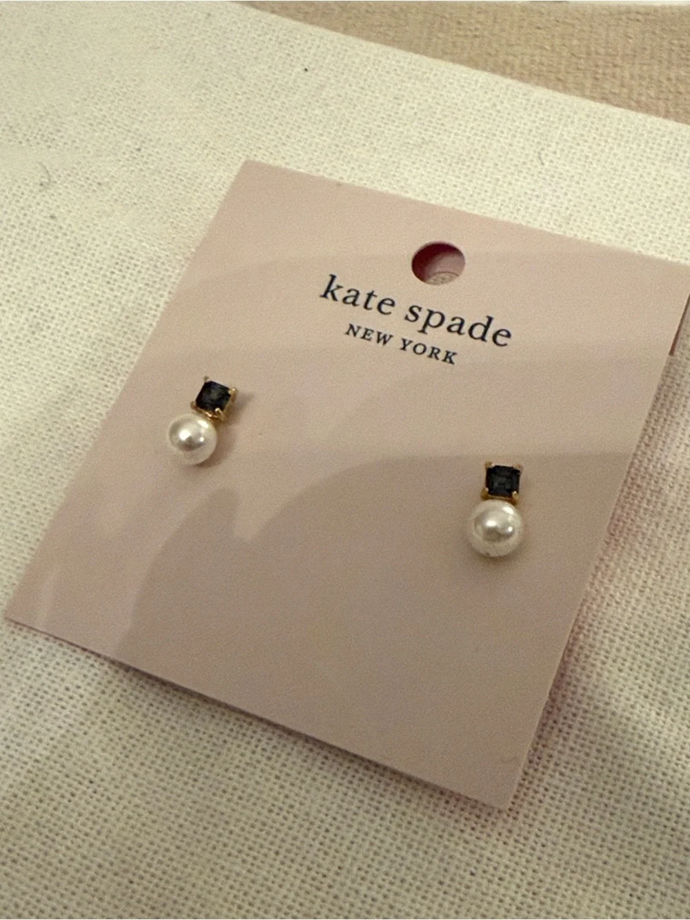 kate spade gold-tone stud earrings with clear backs on pink card